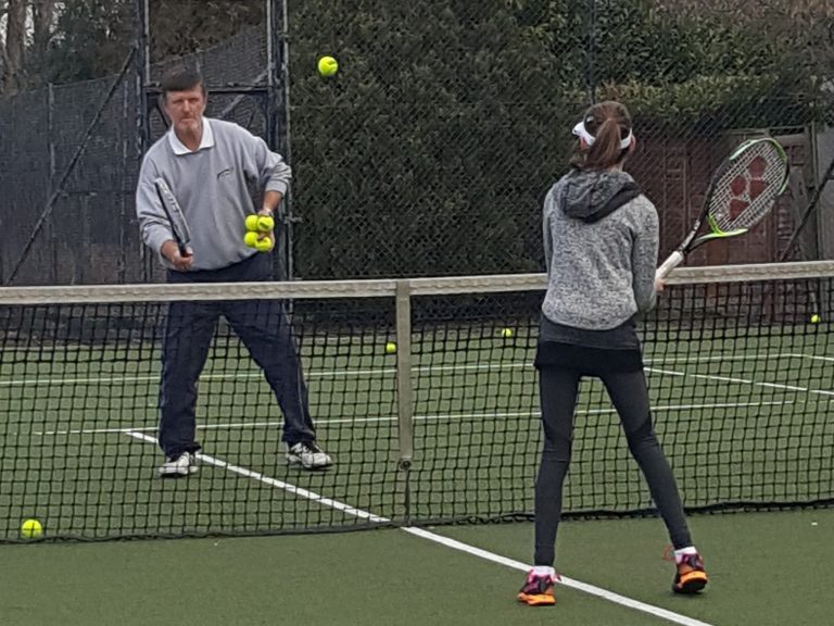 Two members rallying at the net during a winter session