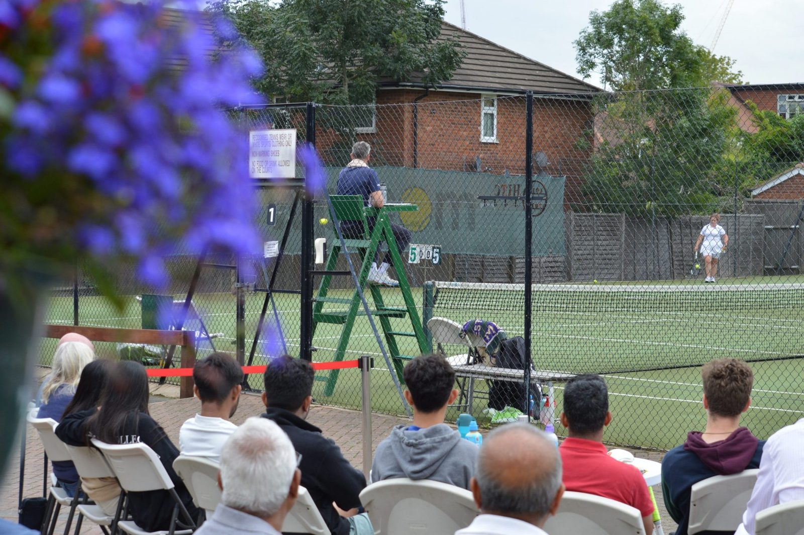 A ladies&rsquo; final in progress on court one at Headstone Tennis Club, with an umpire in the chair and members watching from the terrace
