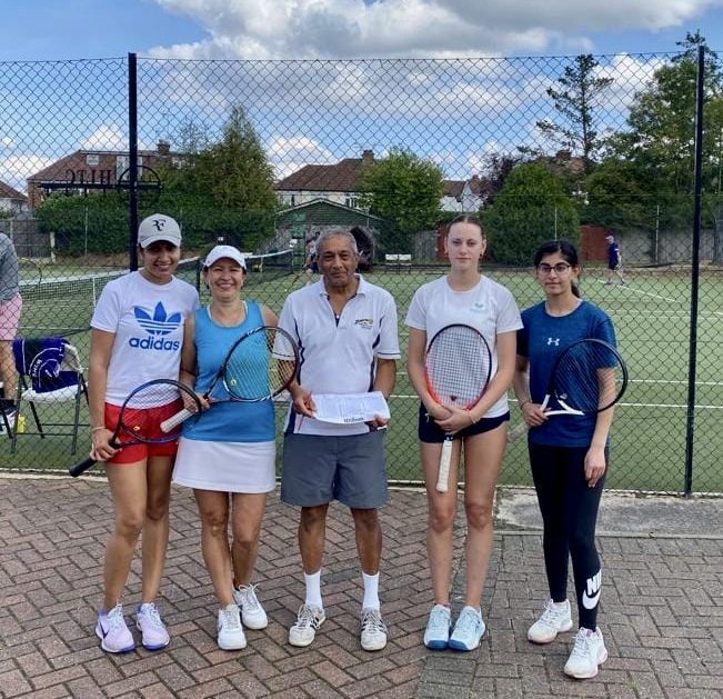 Five Headstone Tennis Club members standing with their rackets on court before a session